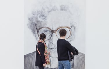 Grande retrato de idosa em preto e branco com duas pessoas olhando para o quadro